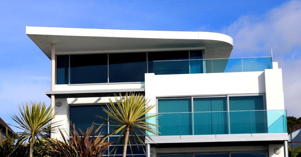 Sleek modern house with glass facade in Poole, UK under blue sky.